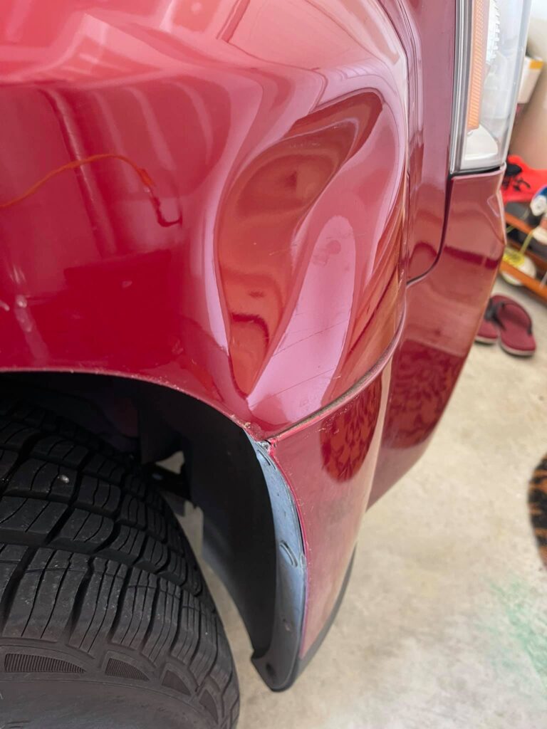 Red Truck Wheel Well Dent Repair Before